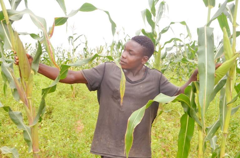 A RUWAI community project beneficiary on his farm during a monitoring visit.
